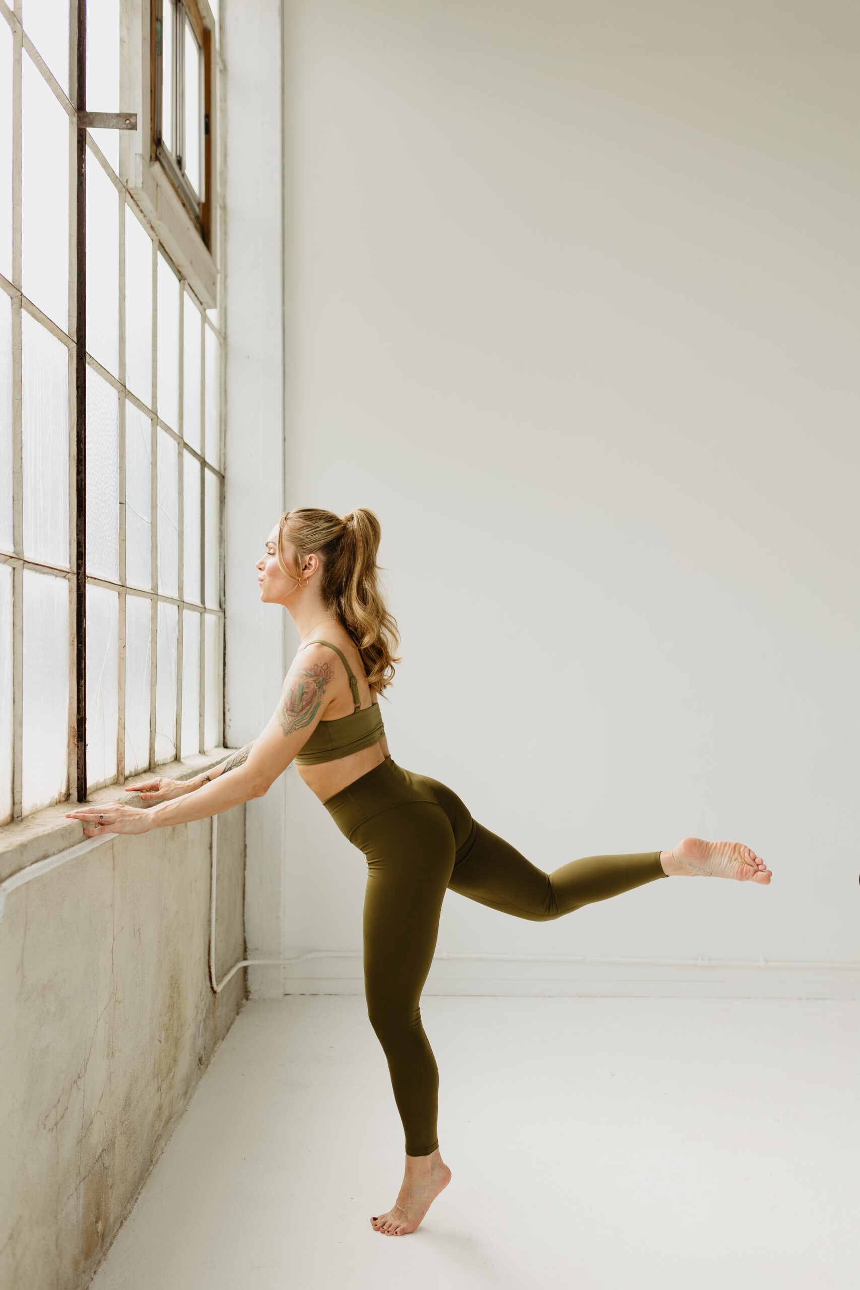 Barre instructor at barre performing a seat workout. Barre complements Yoga perfectly.